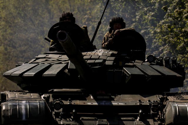 <p>Ukrainian servicemen ride atop of a tank on a road to the frontline town of Bakhmut </p>