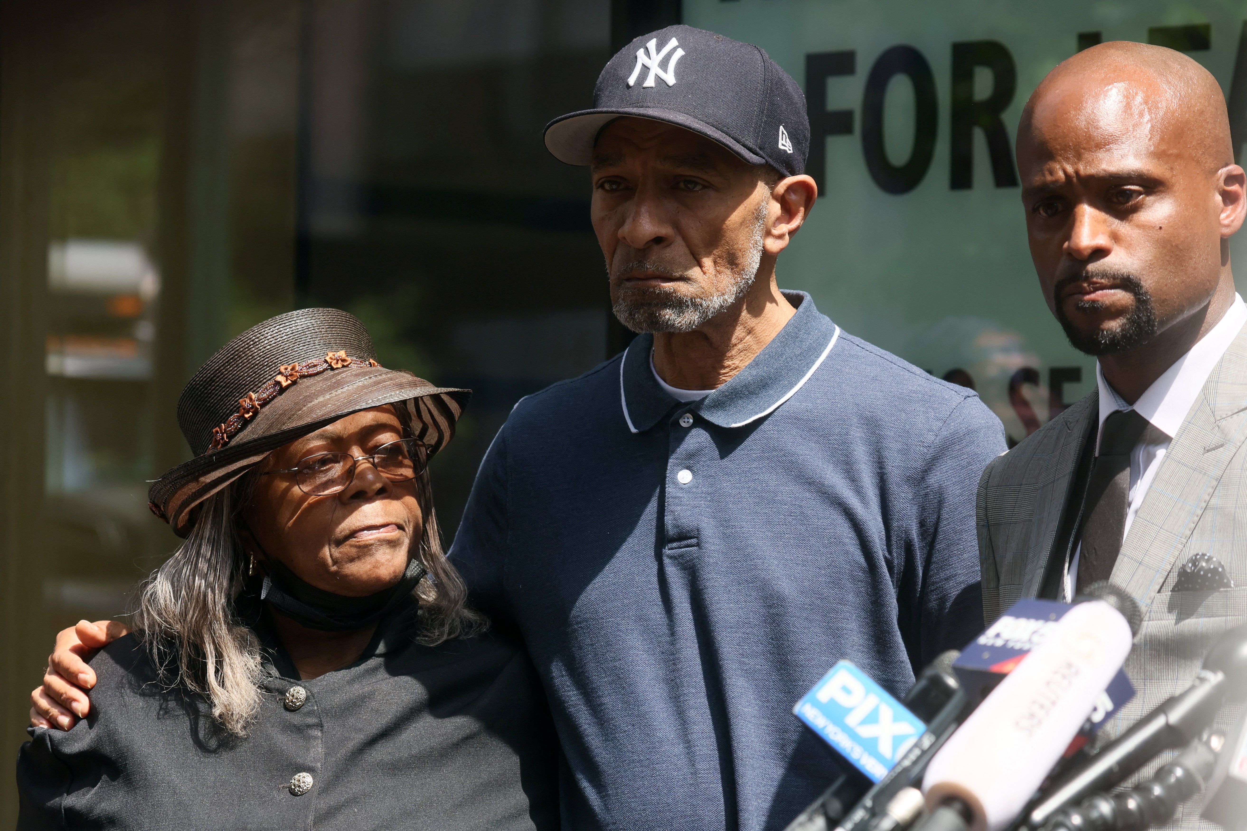 Attorney Donte Mills, right, appeared with Mildred Mahazu and Andre Zachery, the aunt and father of Jordan Neely, respectively, at a press conference on 12 May.