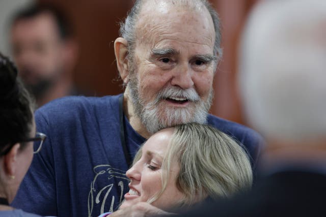 <p>Larry Woodcock hugs an attendee after the verdict was read out in court </p>