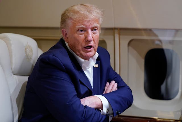 <p> File photo - Former President Donald Trump speaks with reporters while in flight on his plane</p>