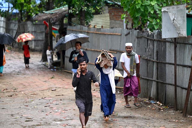 <p>People carry their belongings to a shelter in Shahpori island on the outskirts of Teknaf</p>