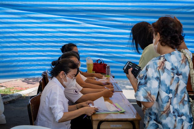 <p>People arrive at a polling station to cast their ballots for the Thailand General Election</p>