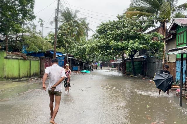<p>local people walk on a flooded street caused by heavy rain</p>