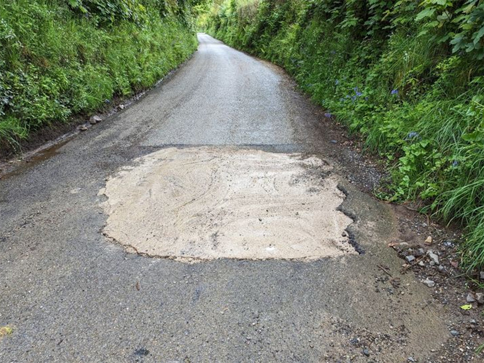 A mystery motorist poured concrete into a huge pothole