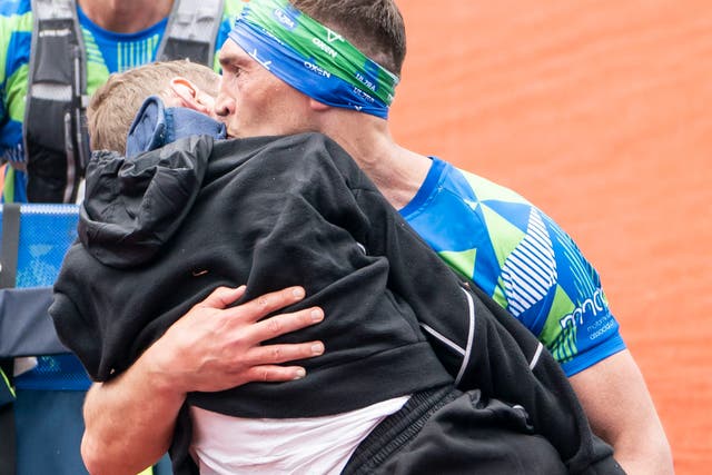 <p>Kevin Sinfield carries Rob Burrow across the finish line of the Leeds Marathon </p>