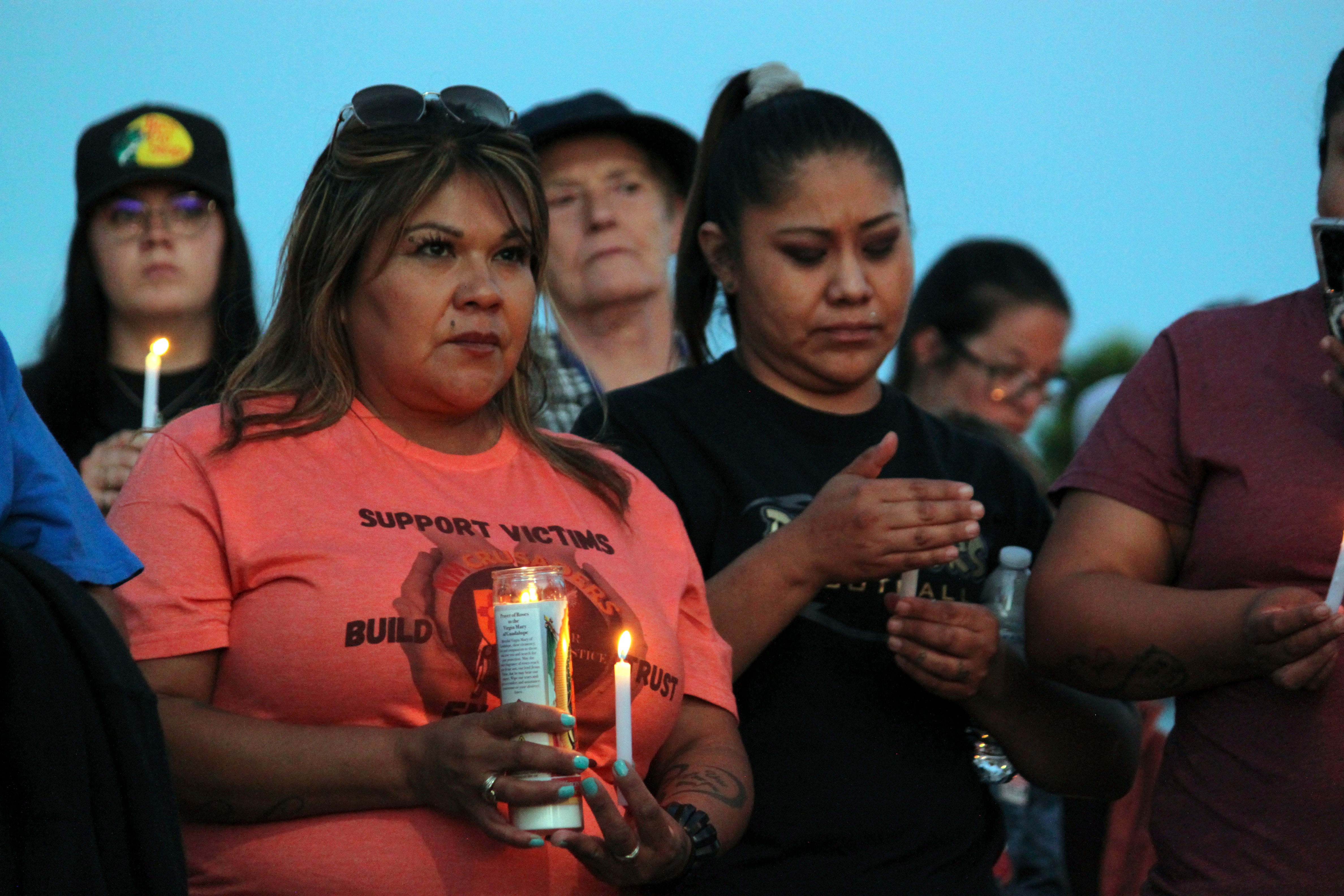 Community members hold candles during a prayer vigil at Hills Church, Monday, in Farmington, New Mexico.
