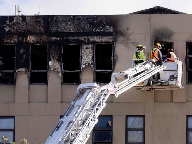 <p>Firefighters inspect the Loafers Lodge hostel where a fire broke out</p>