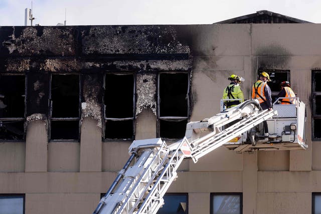<p>Firefighters inspect the Loafers Lodge hostel where a fire broke out</p>