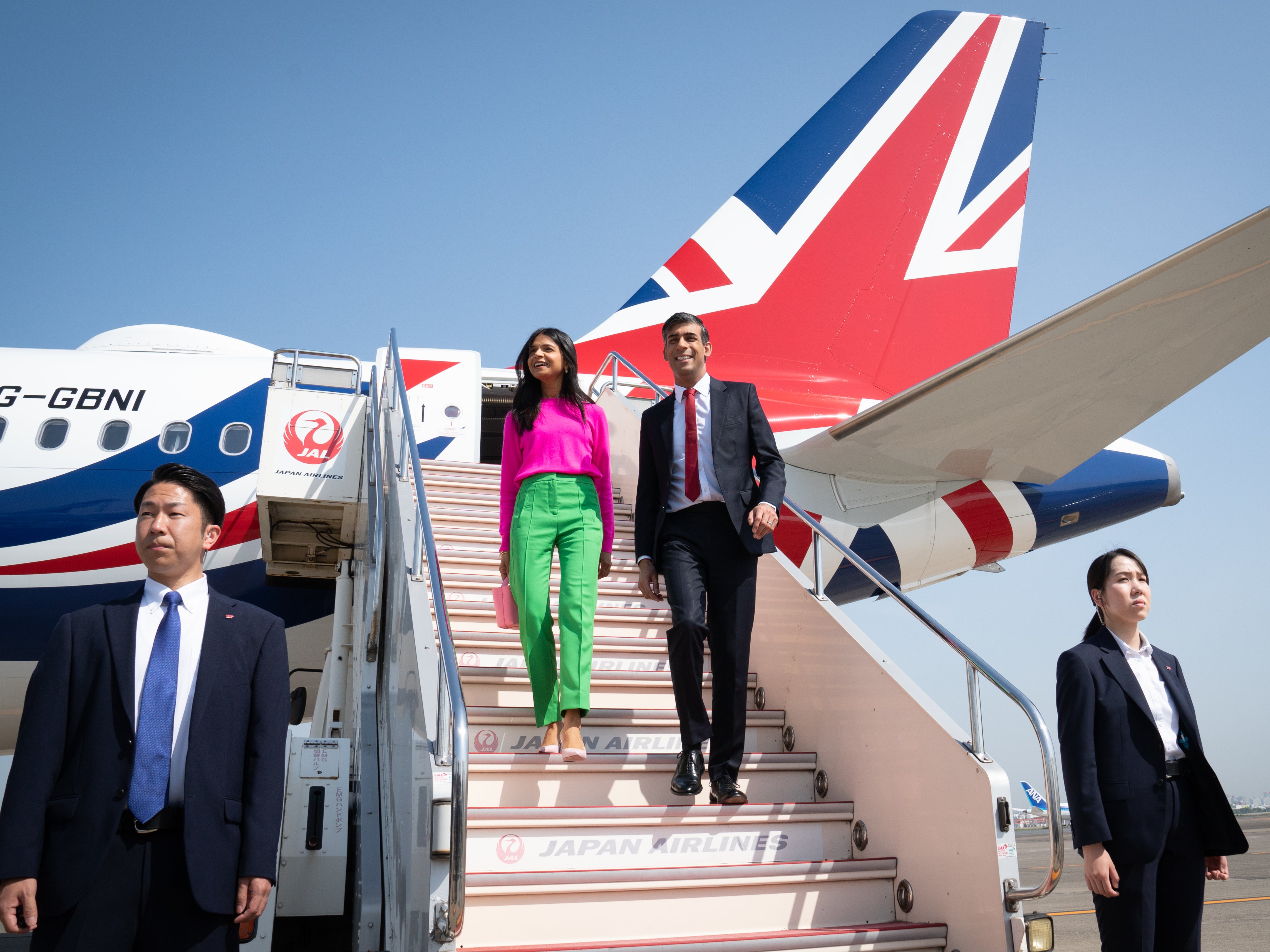 Rishi Sunak and his wife Akshata Murty disembark their plane as they arrive at Tokyo