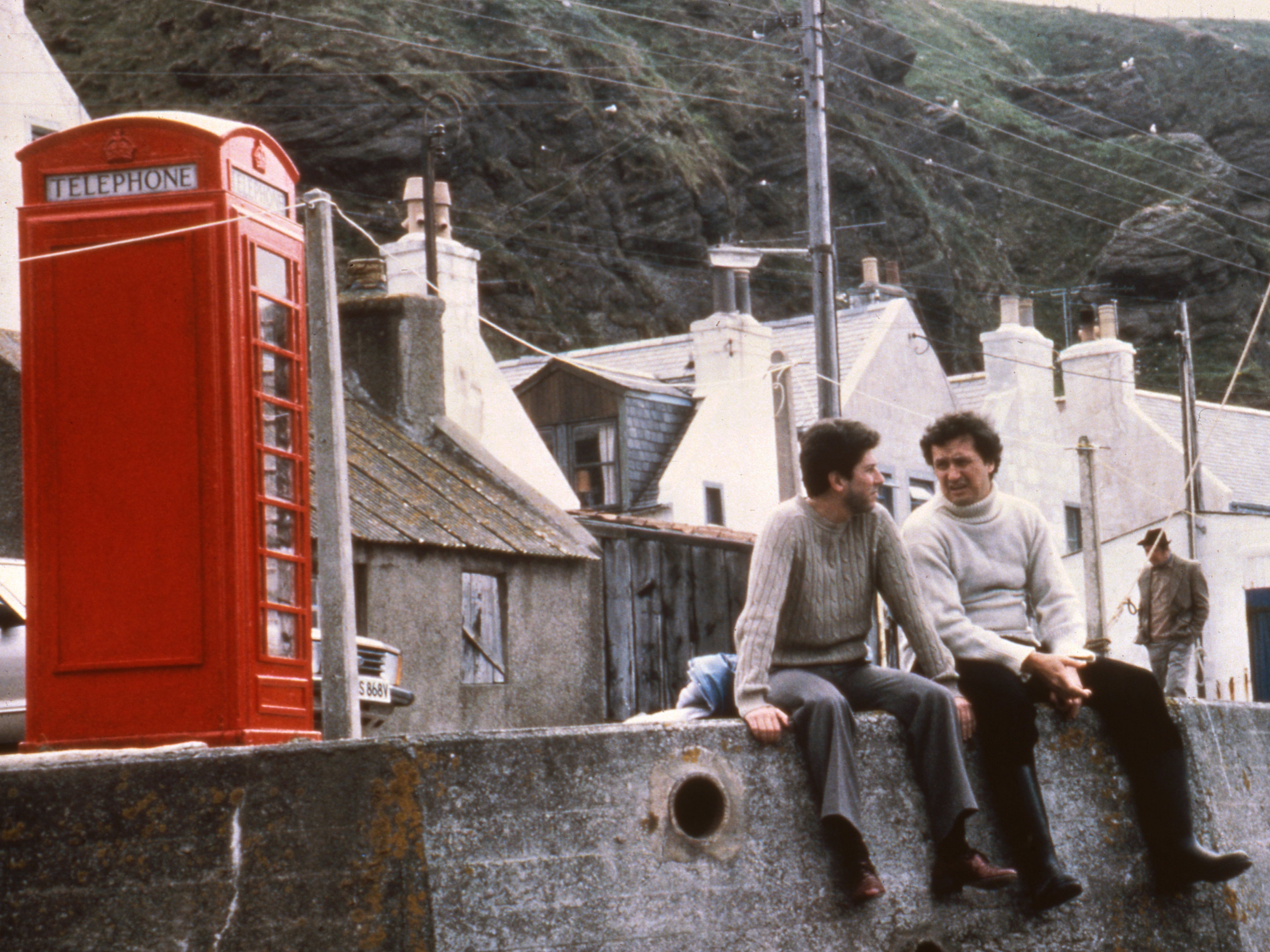 Riegert as Mac and Chris Rozycki as Victor next to the film’s famous red phone box in the Aberdeenshire village of Pennan