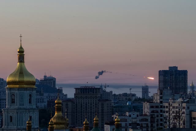 <p>An explosion of a missile is seen in the sky over the city during a Russian missile strike in Kyiv</p>