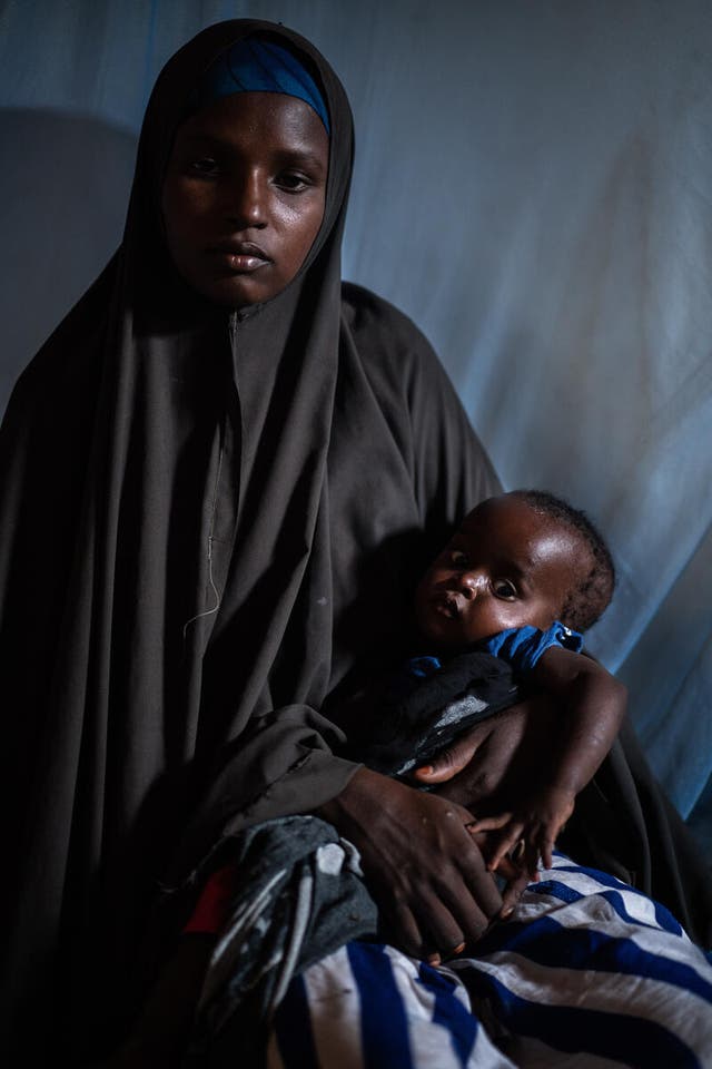 <p>Mother-of-three Naima* was photographed sitting with her baby daughter Najma* in a stabilisation centre in Baidoa</p>