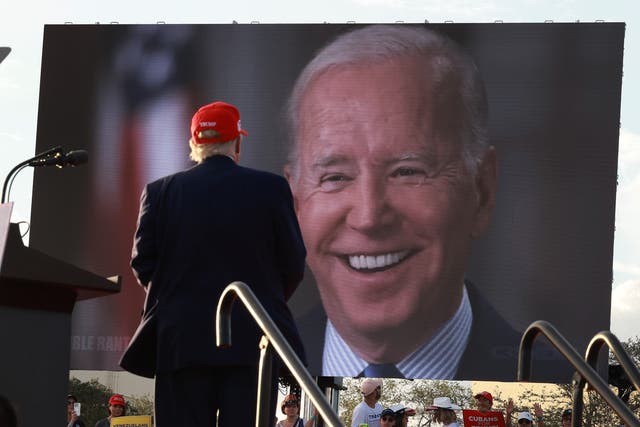 <p>Donald Trump watches a video of Joe Biden playing during a rally (2022)</p>