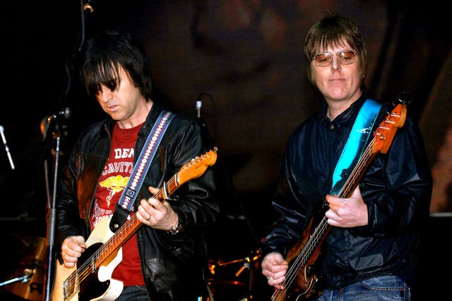Andy Rourke, right, and Johnny Marr on stage together concert (PA)