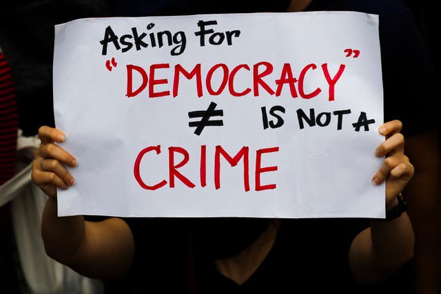 <p>File: A pro-democracy protester holds a placard ‘Asking For Democracy Is Not A Crime’ during an anti-government protest in Bangkok</p>