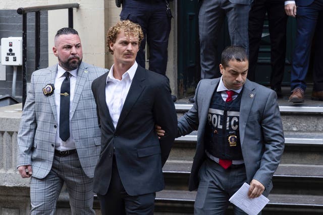 <p>Daniel Penny, centre, is walked by New York police detectives out of the 5th Precinct on 12 May 2023, in New York City </p>