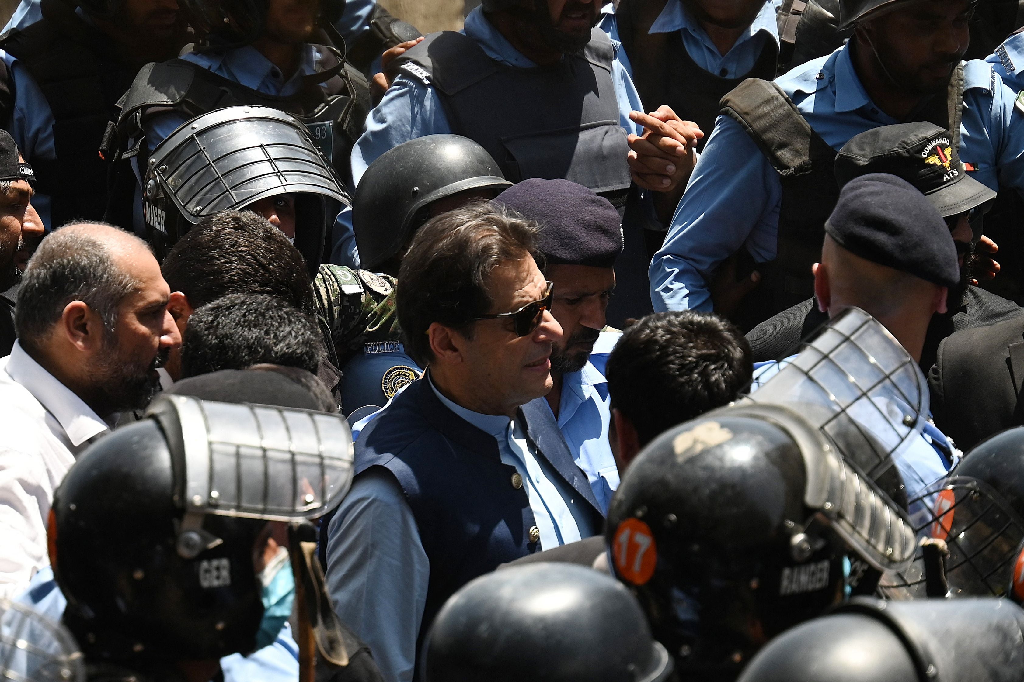 File. Police cammandos escort former Pakistan’s prime minister Imran Khan (C) as he arrives at the high court in Islamabad