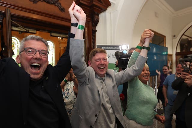 Sinn Fein’s Padraig Donnelly (centre) and Irish Senator Niall ODonnghaile (left) celebrate winning a seat at the Northern Ireland council elections at Belfast City Hall (