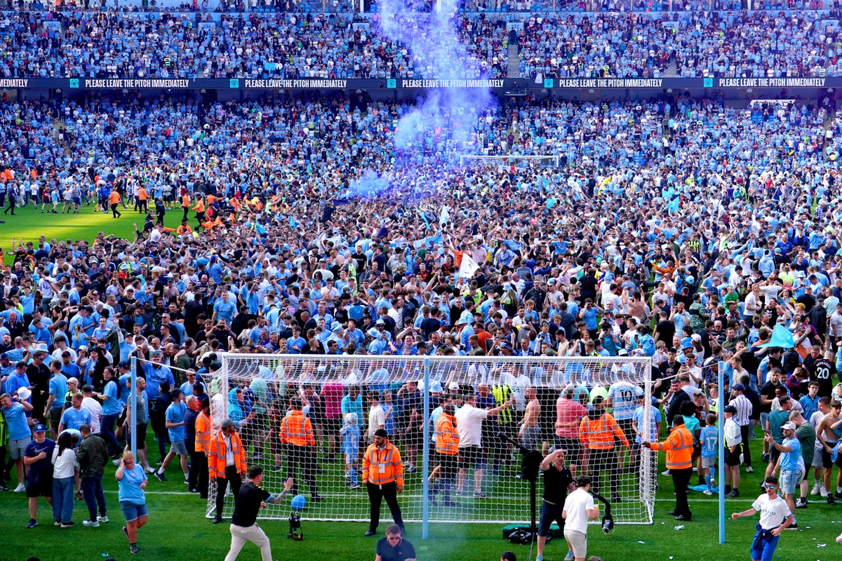 Manchester City players and fans celebrate step one of the treble