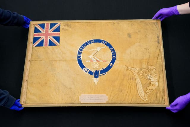 Conservators from the National Museum of the Royal Navy move the Kellet Sledge flag after it was taken out of it’s frame for inspection at Portsmouth Historic Dockyard in Hampshire. Picture date: Wednesday May 16, 2023.