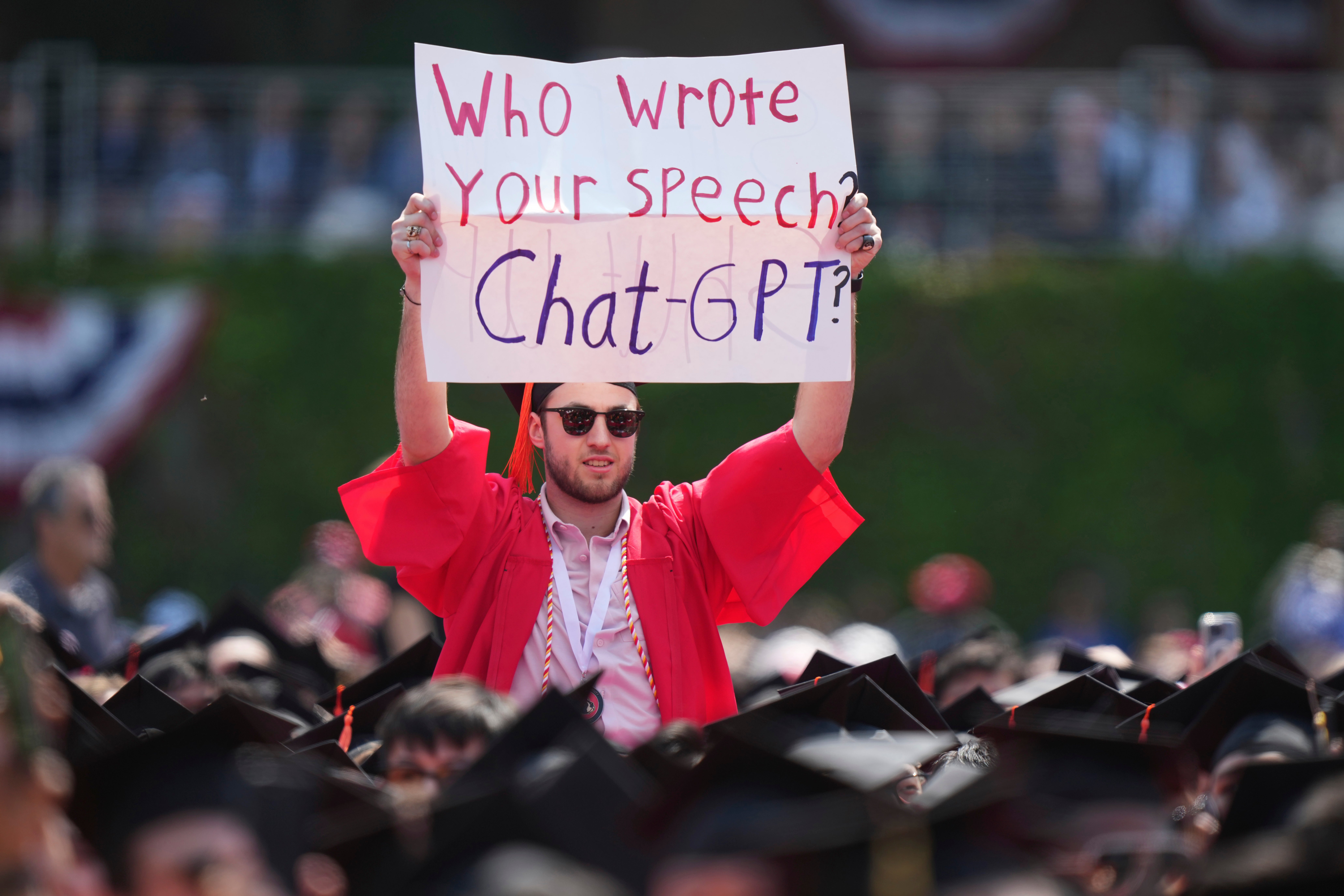 A protester holds a sign during an address by Zaslav at a Boston University commencement ceremony in May