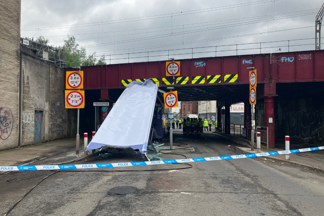 An investigation is under way after a double-decker bus hit a railway bridge and had its roof sheared off, leaving 10 people needing hospital treatment (Network Rail/PA)