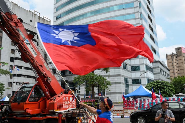 <p>A man waves a Taiwanese flag during a rally</p>