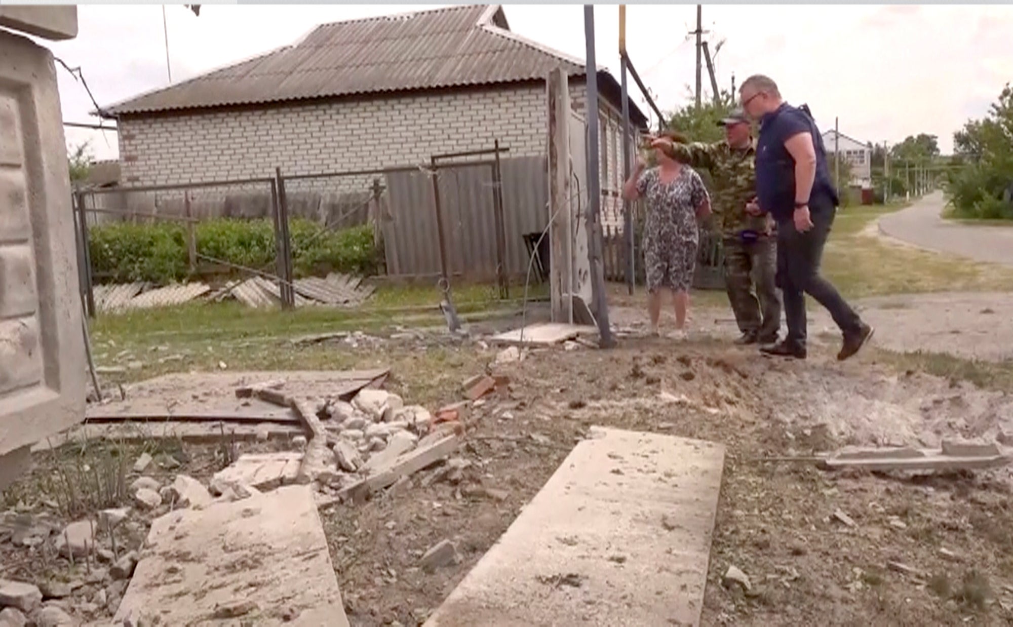 <p>This image taken from a video shows people indicating a damaged building in the Belgorod region, Russia</p>