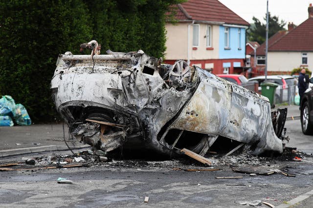 Council workers secure the area immediately around a car that was set alight in Ely, Cardiff (PA)