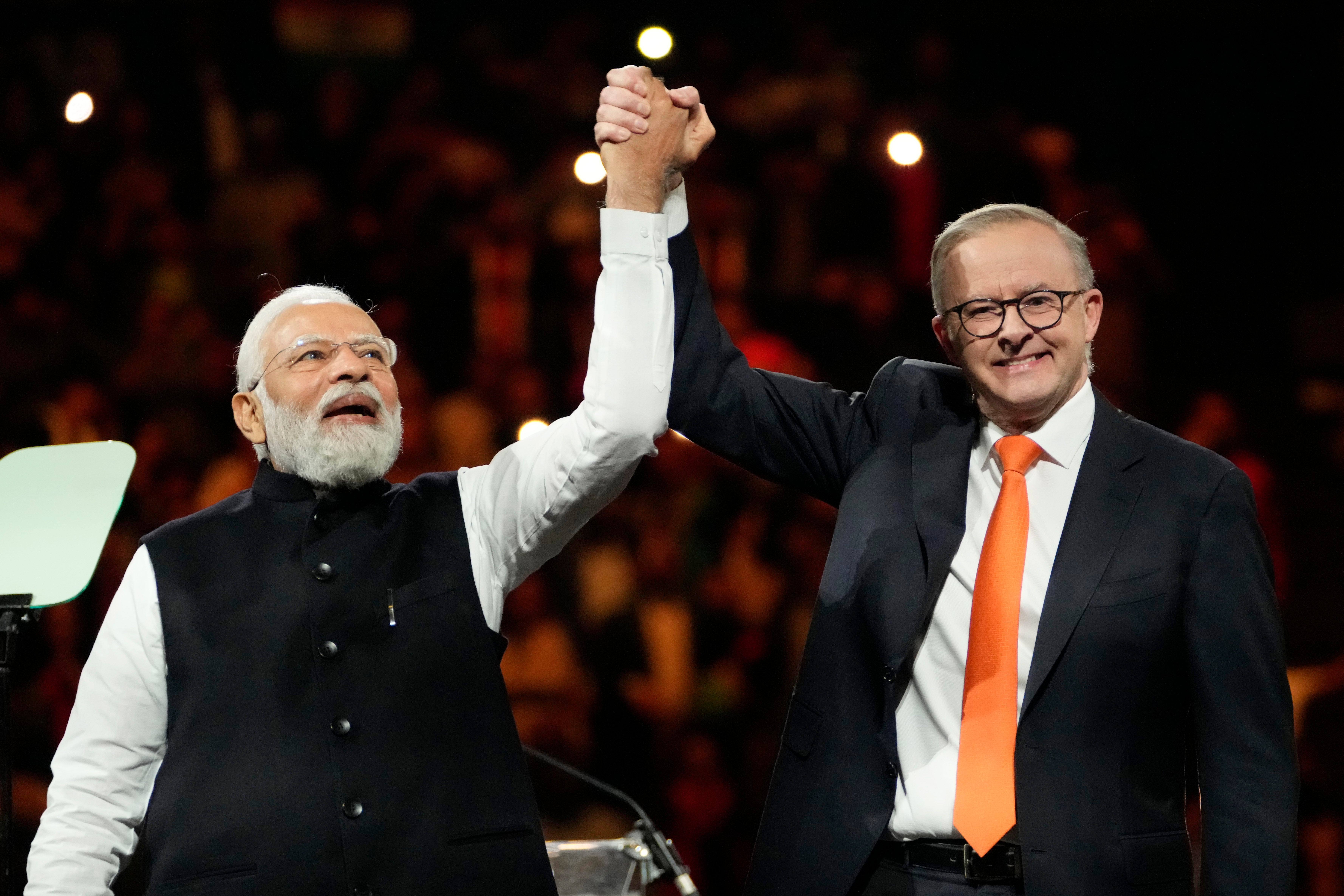 Indian Prime Minister Narendra Modi, left, holds hands with his Australian counterpart Anthony Albanese