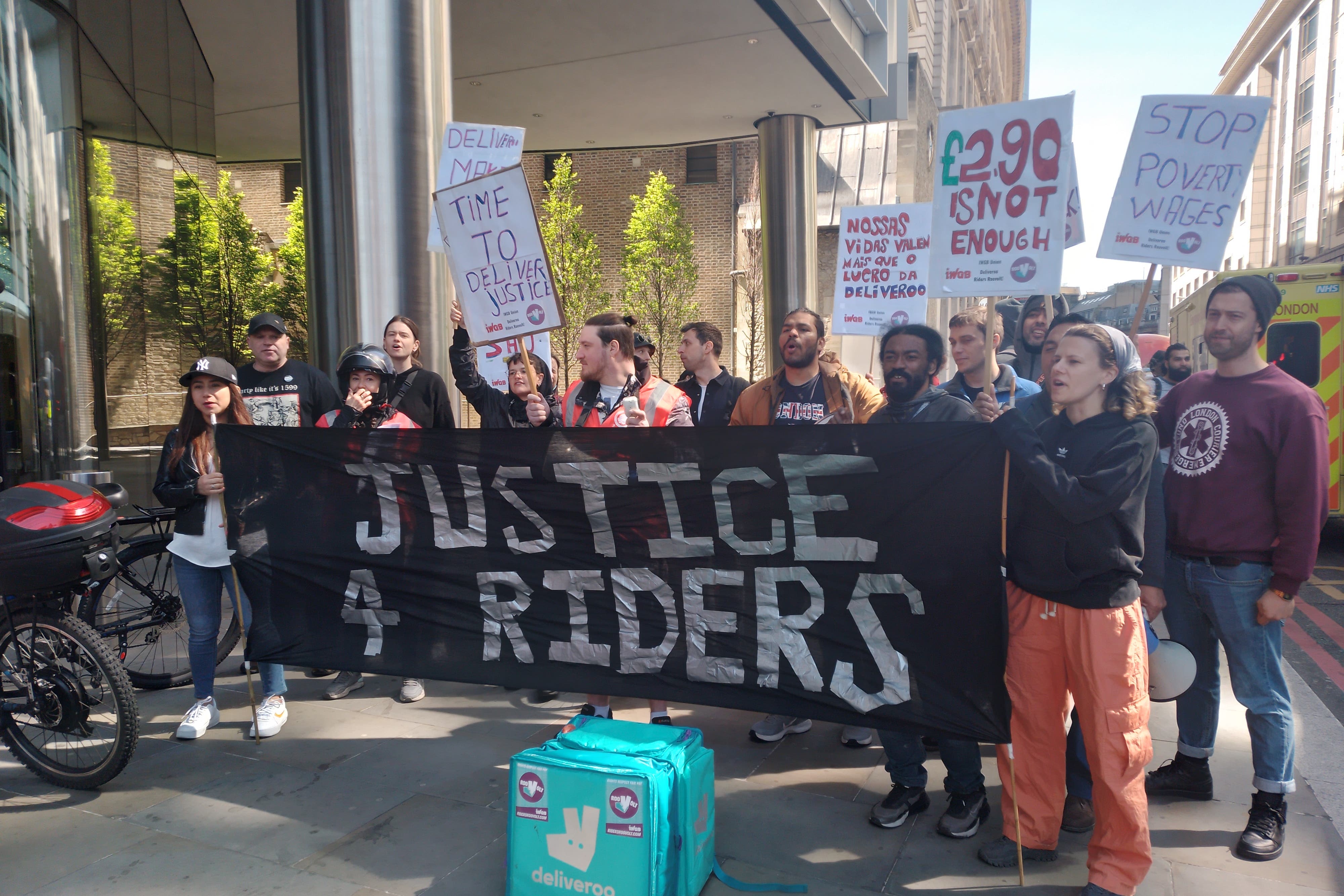 Deliveroo riders gather outside 100 Bishopsgate, London, to protest against the company’s working conditions and low pay (Flora Bowen/PA)