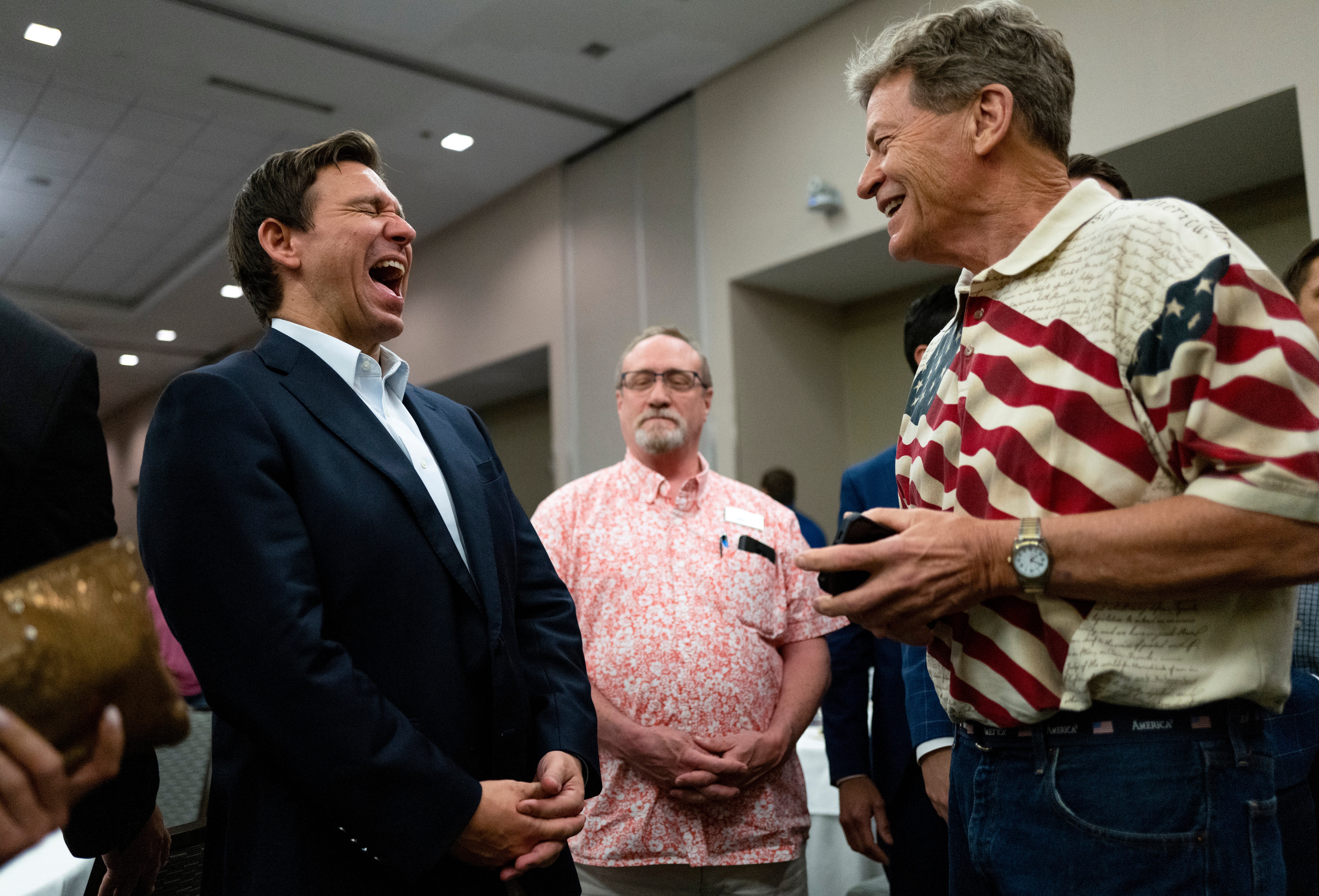 Ron DeSantis shares a joke with voters during an Iowa GOP reception in Cedar Rapids