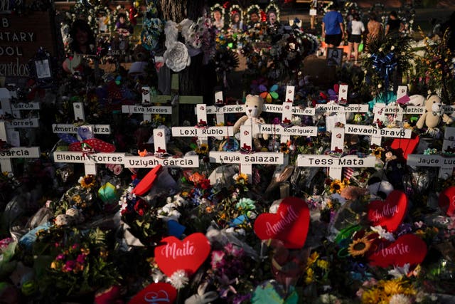 <p>Flowers are piled around crosses with the names of the victims killed in a school shooting as people visit a memorial at Robb Elementary School to pay their respects May 31, 2022, in Uvalde, Texas.</p>