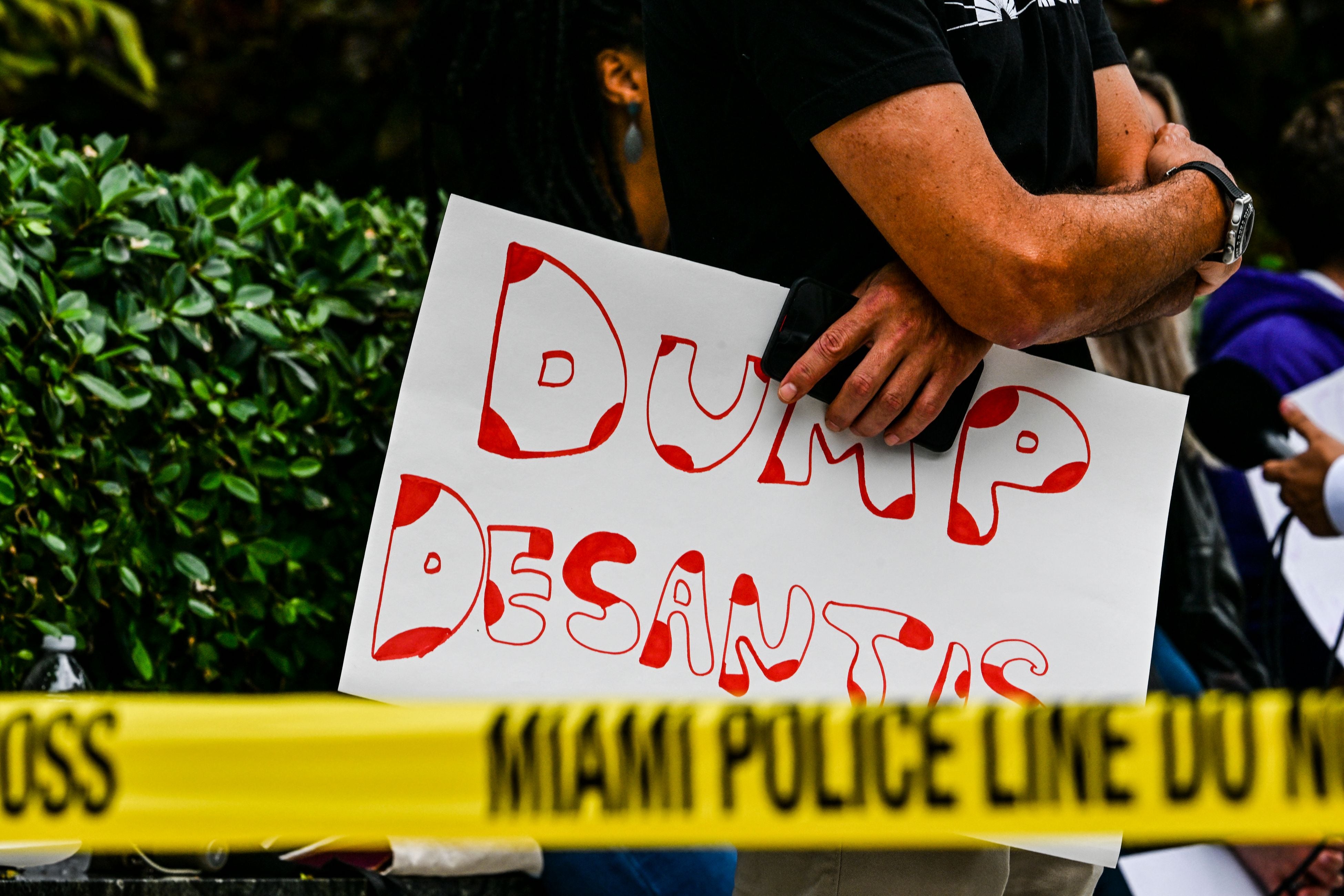Protesters gather outside the Four Seasons Hotel in Miami on 24 May as the governor holds fundraising events ahead of his presidential candidacy announcement.