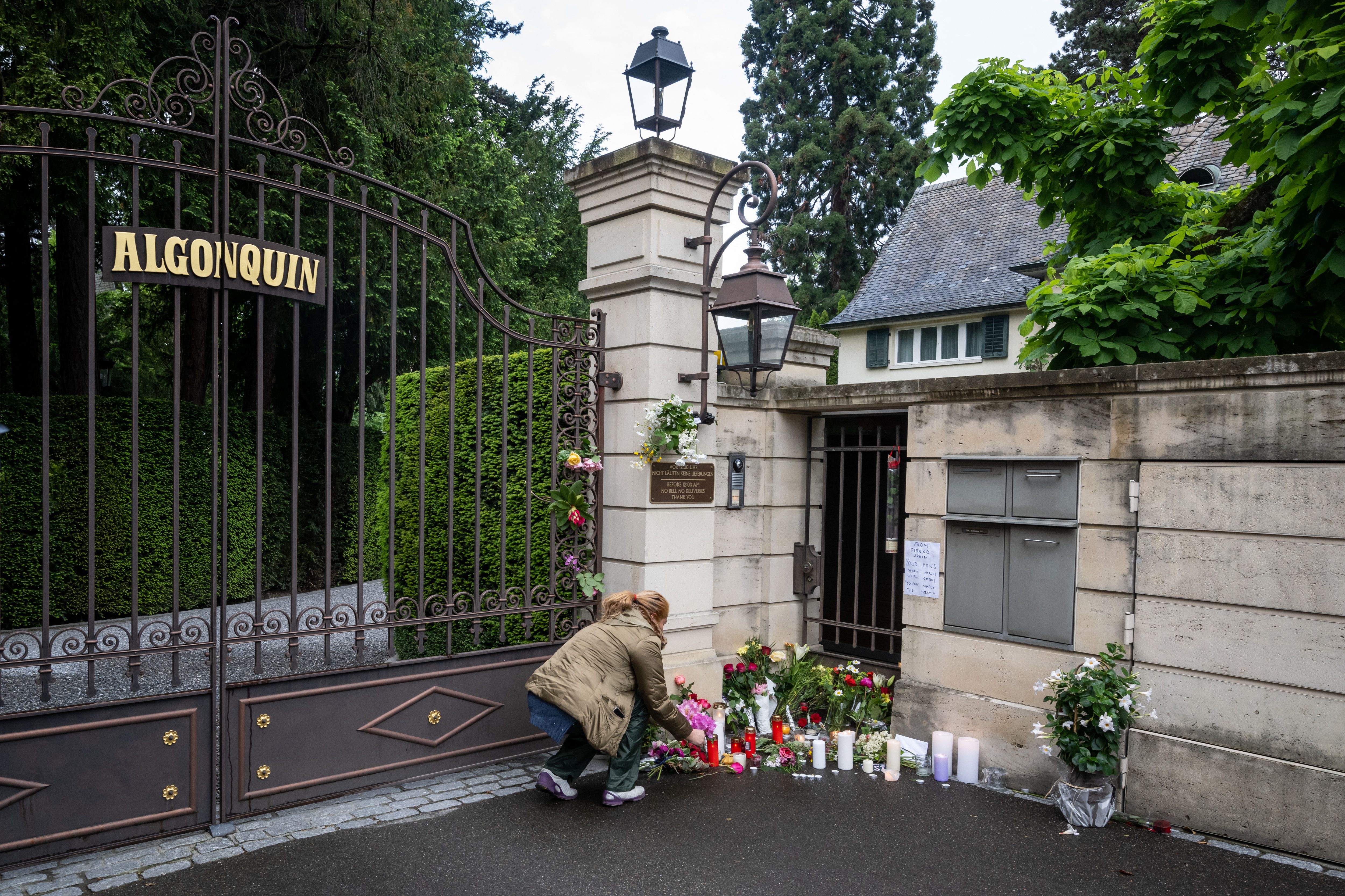 A mourner lays flowers outside the estate of late singer Tina Turner in Kusnacht