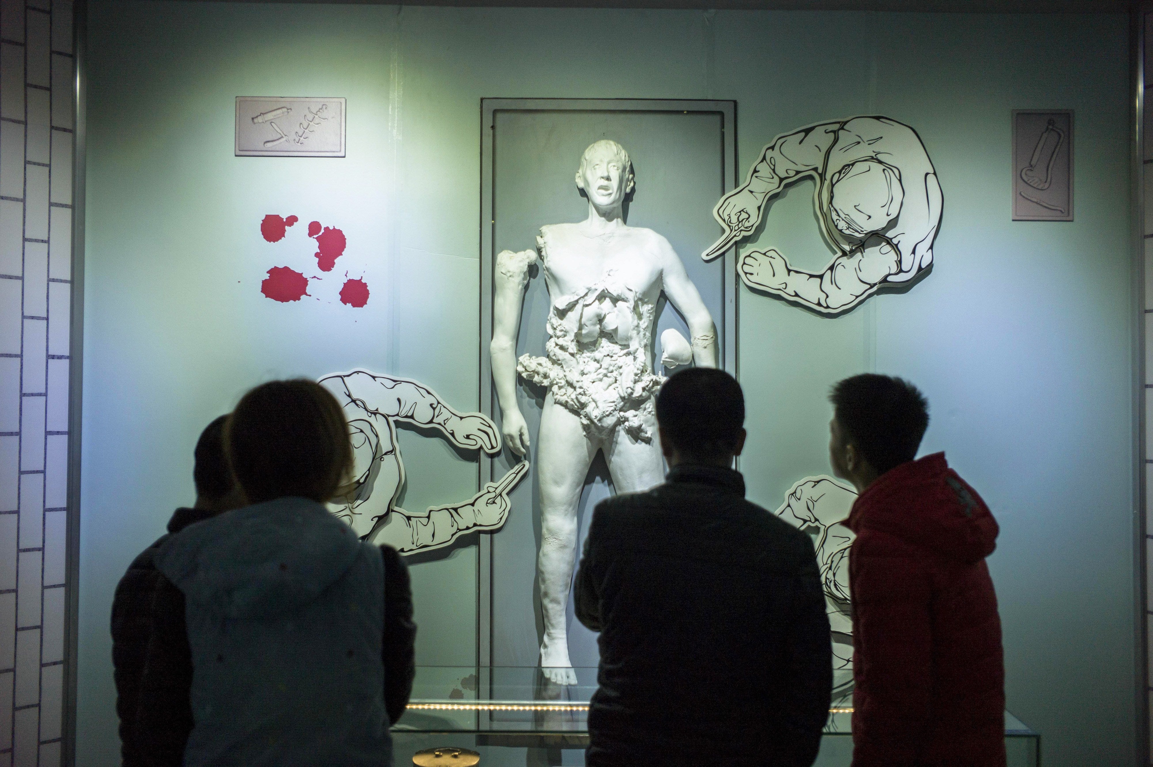 Visitors look at a scene depicting human experiments at the Unit 731 museum in Harbin in northeast China’s Heilongjiang province
