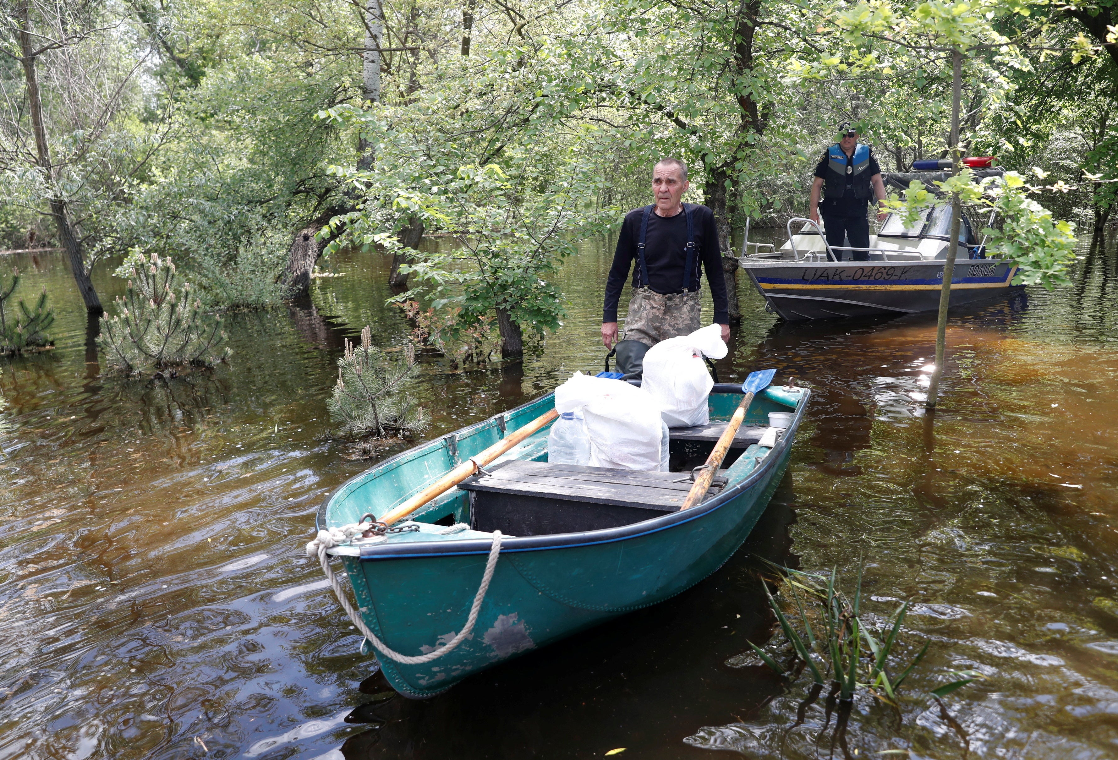 <p>Ihor Medunov walks next to a police boat on a flooded island which locals and officials say is caused by Russia’s chaotic control of the Kakhovka dam downstream, amid Russia’s attack on Ukraine, near Zaporizhzhia</p><p>” height=”2419″ width=”3558″ layout=”responsive” class=”i-amphtml-layout-responsive i-amphtml-layout-size-defined” i-amphtml-layout=”responsive”><i-amphtml-sizer slot=