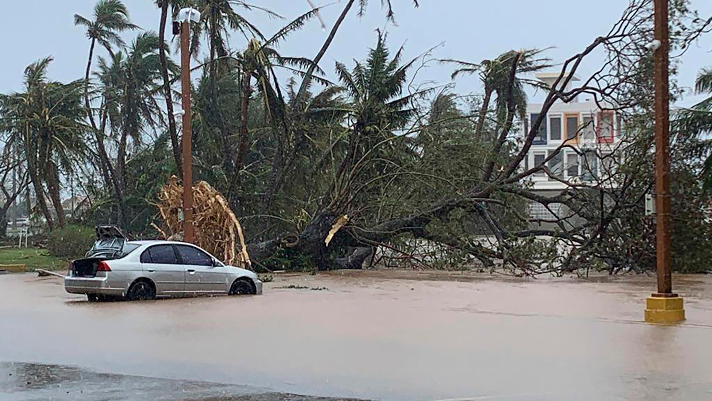 The waters of the Hagatna River overflows its banks and encroaches into the Bank of Guam parking lot in Hagatna, Guam