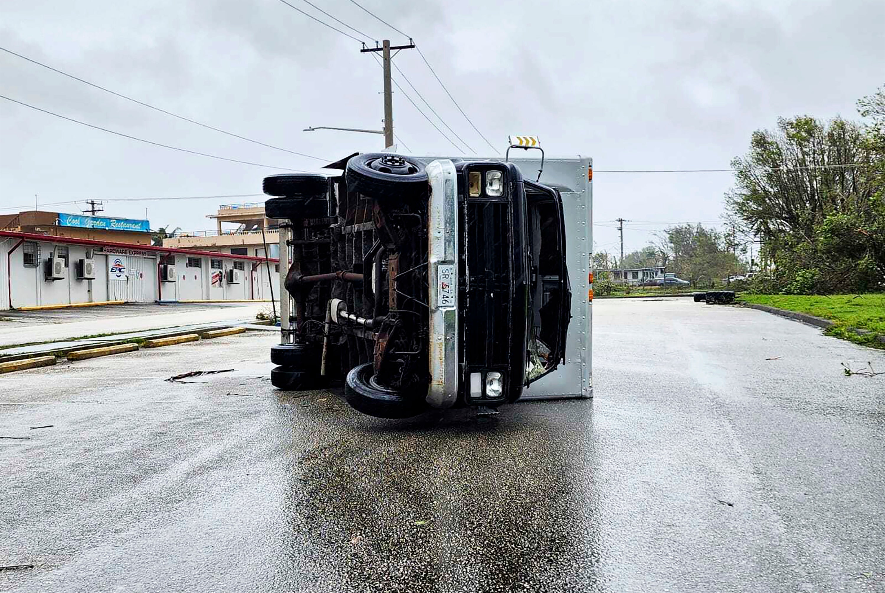An overturned truck lies on a street Thursday in Guam