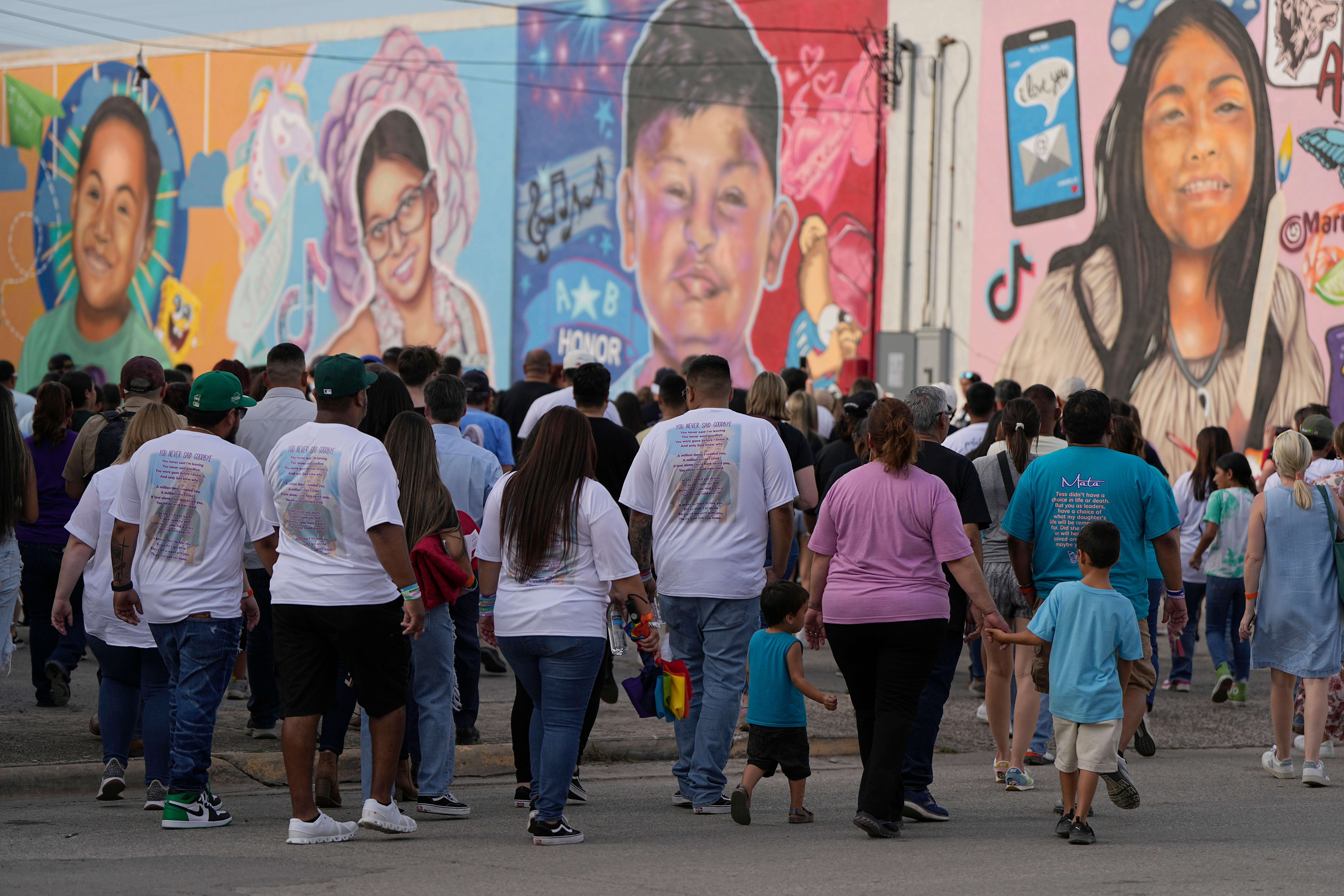 Mourners walk next to a mural of shooting victims before a candlelight vigil in Uvalde, Texas, Wednesday, May 24, 2023 on the one year anniversary of the rampage