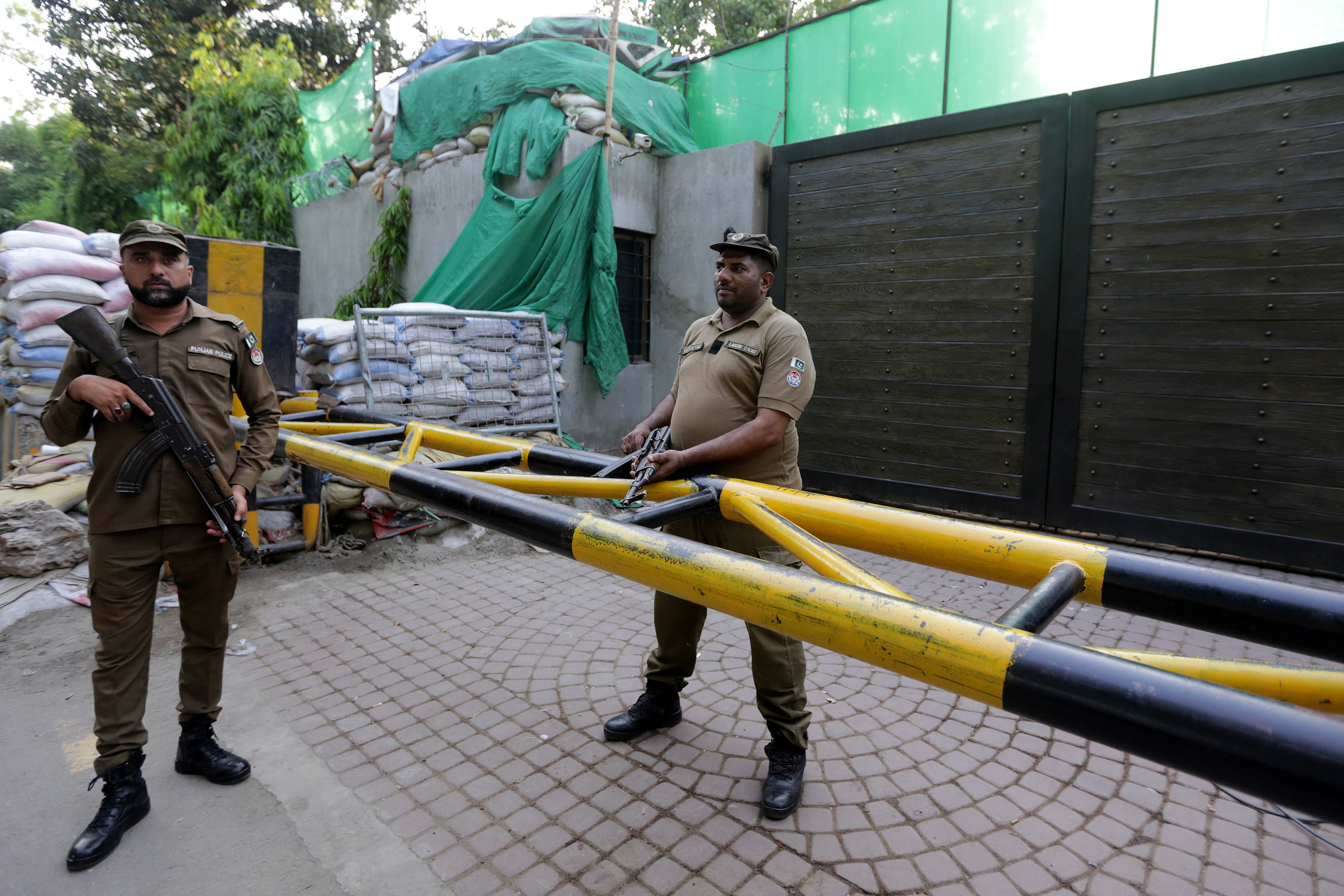 Pakistani security officials stand guard as Lahore Commissioner Muhammad Ali Randhawa searches the residence of former Pakistani Prime Minister Imran Khan at Zaman Park on 19 May