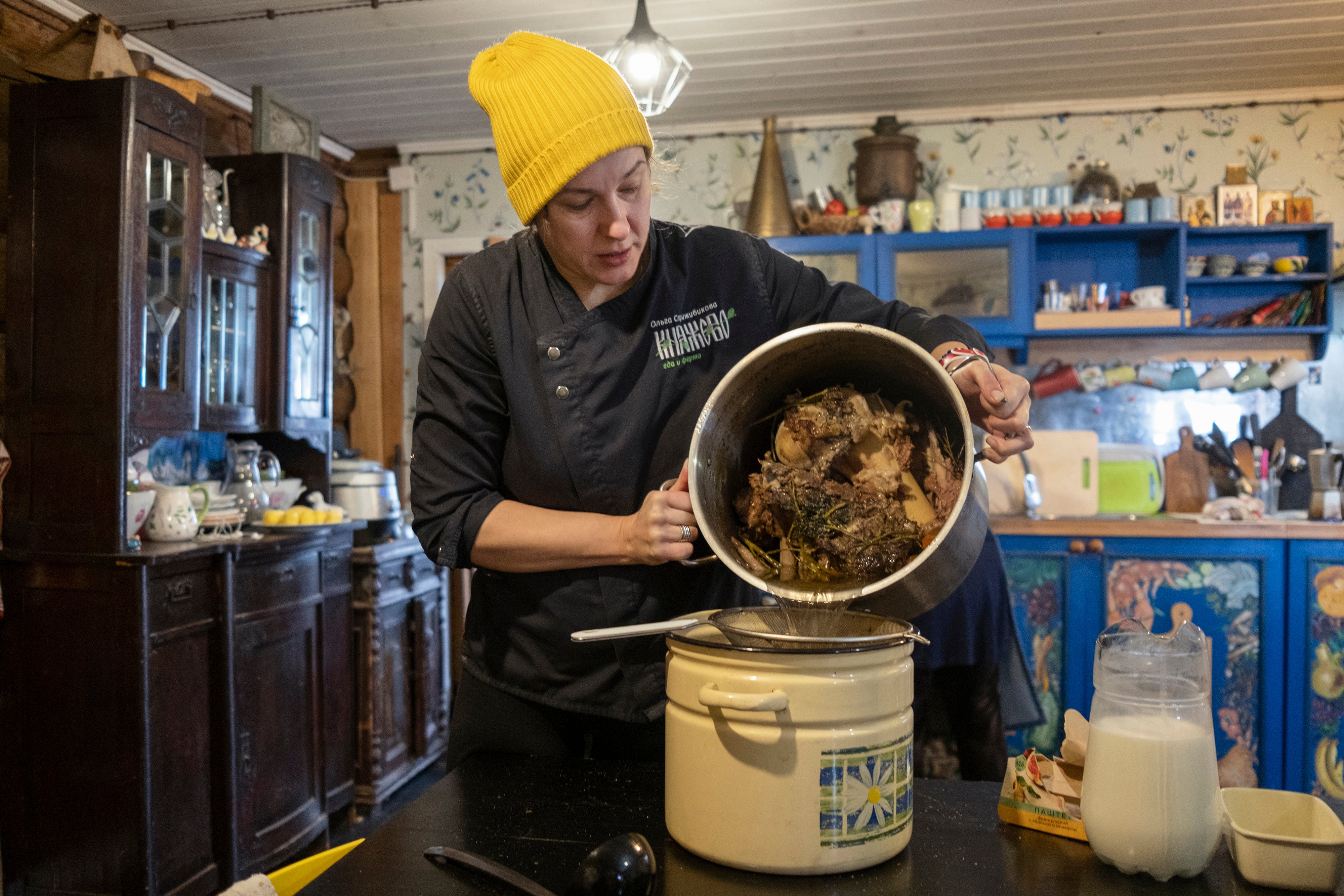 Olga Strizhibikova stains broth into a pot