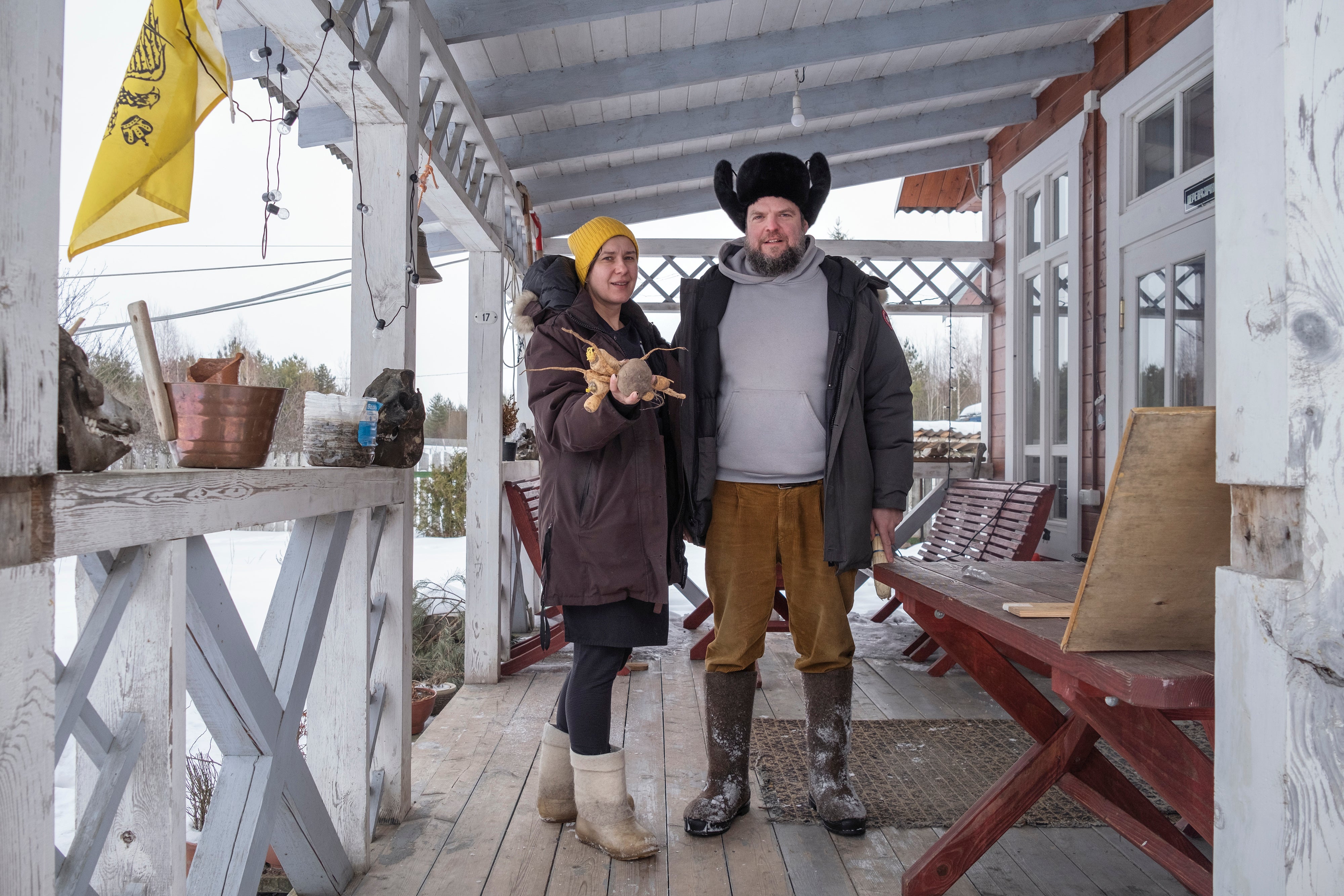 Boris Akimov and Olga Strizhibikova stand on the porch of their restaurant