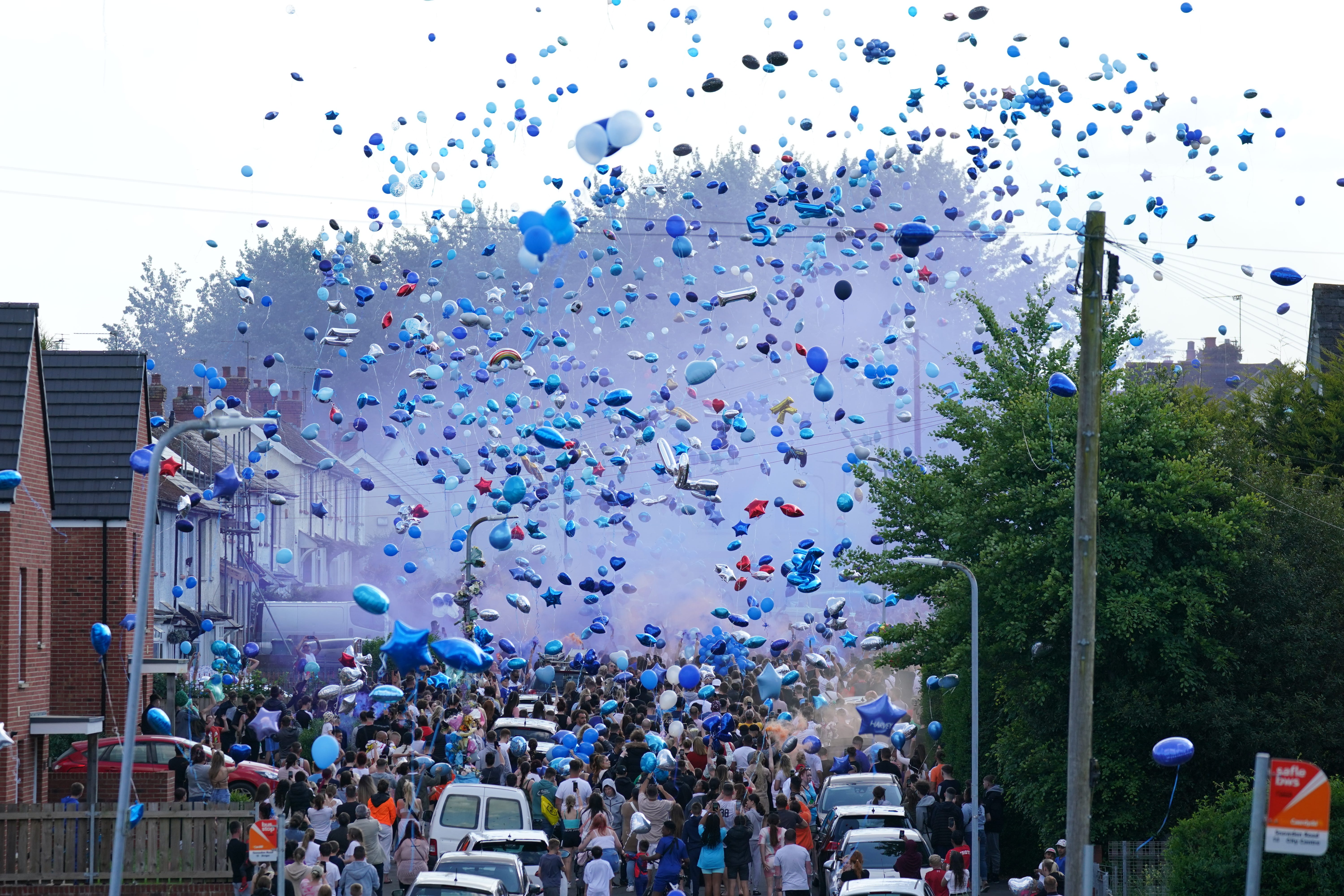 People release balloons during a vigil for the victims of a road traffic collision on Snowden Road in Ely, Cardiff (Jacob King/PA)