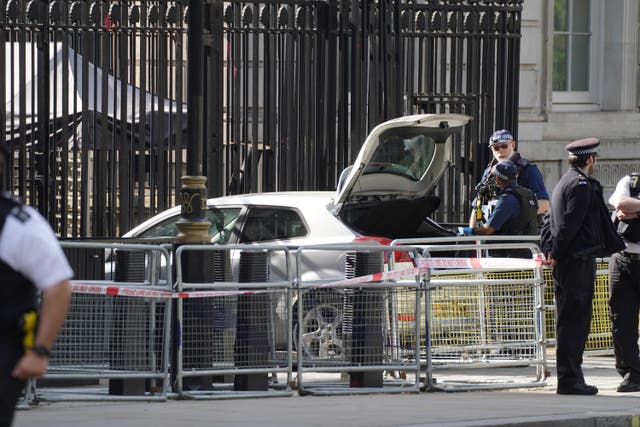 <p>Police at the scene after Seth Kneller’s car collided with the gates of Downing Street (James Manning/PA)</p>
