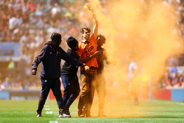<p>A man wearing a Just Stop Oil T-shirt invades the Twickenham pitch </p>
