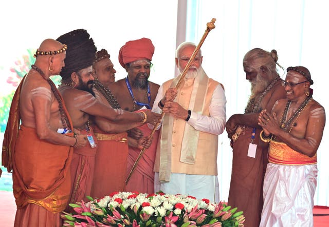 <p>Hindu priests hand a royal golden sceptre to Indian prime minister Narendra Modi during the inaugural ceremony of the new parliament building, in New Delhi on Sunday</p>
