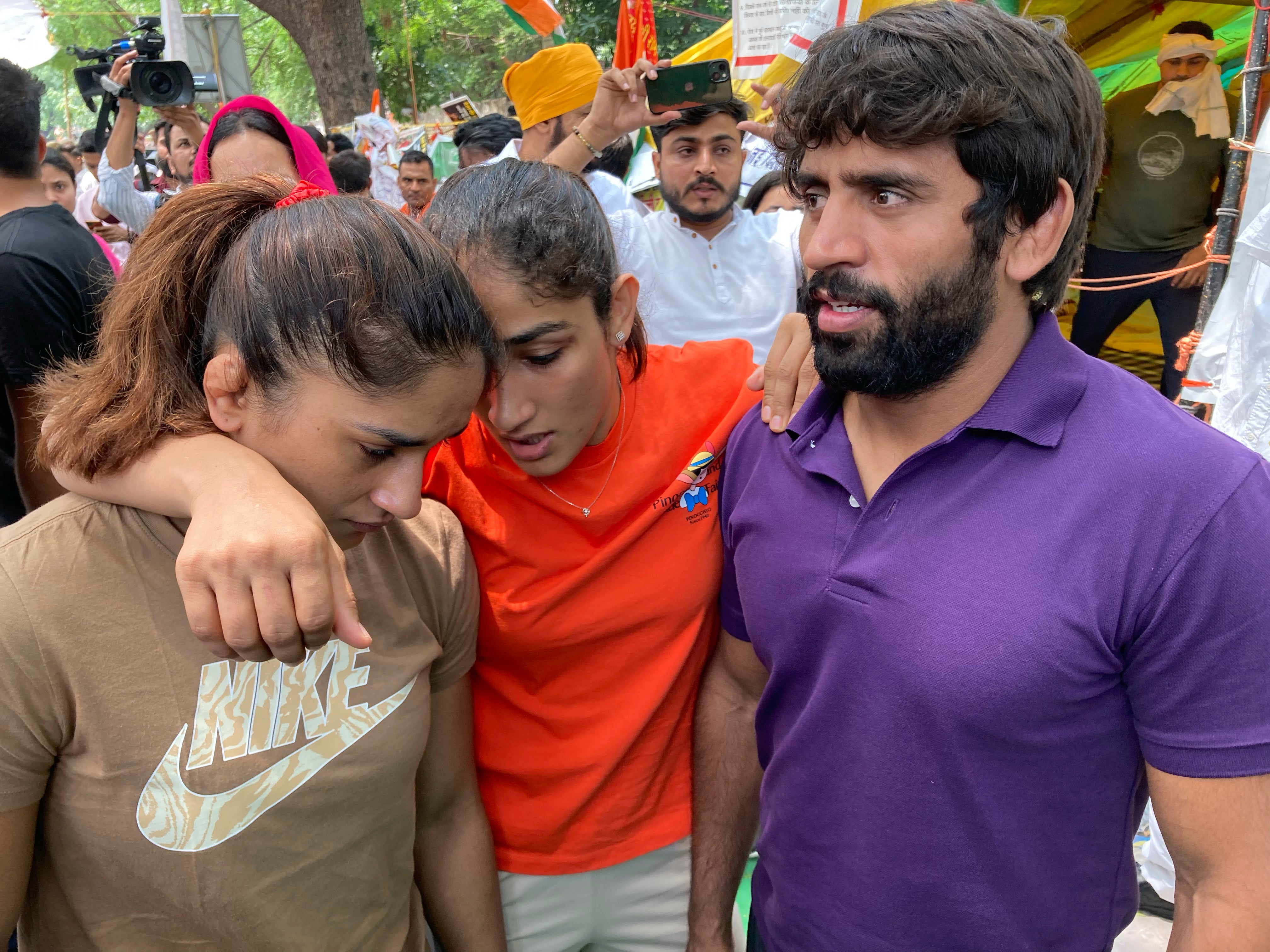 Indian wrestlers (from right) Bajrang Punia, Sangita Phogat and Vinesh Phogat talk to each other ahead of their protest march