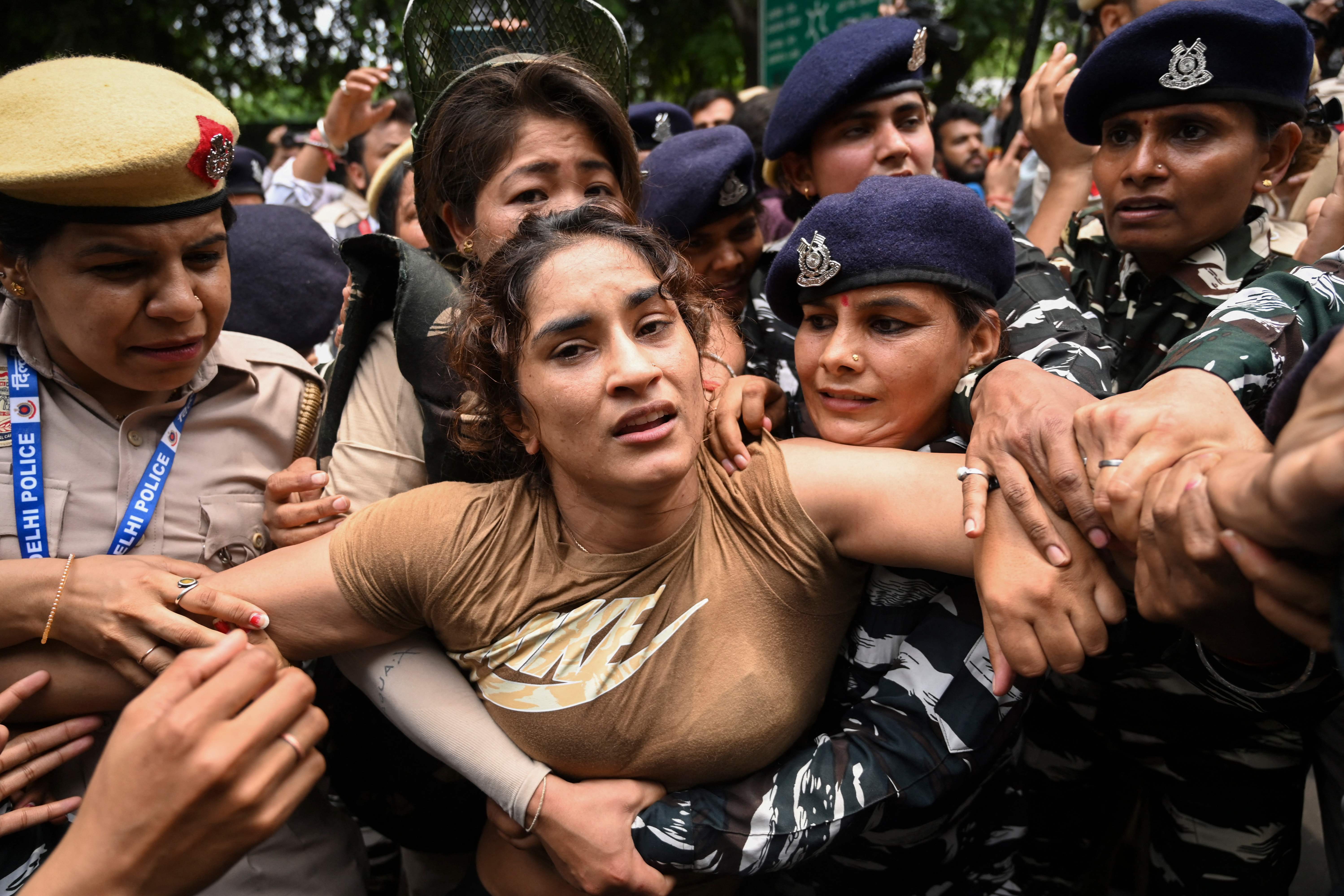 Indian wrestler Vinesh Phogat (centre) is detained by the police while attempting to march to India’s new parliament