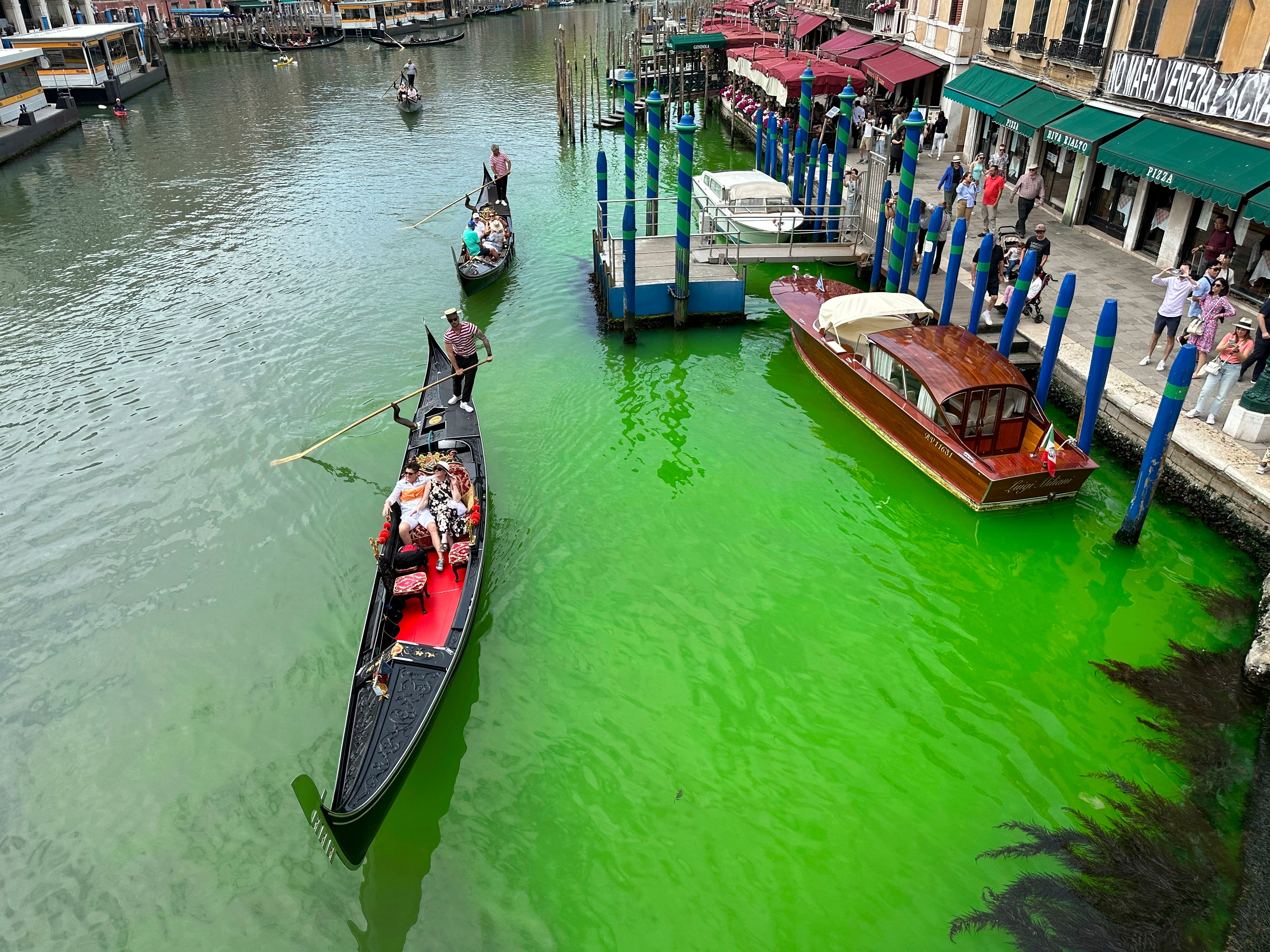 Photos show the section of the canal by an embankment lined with restaurants turned green